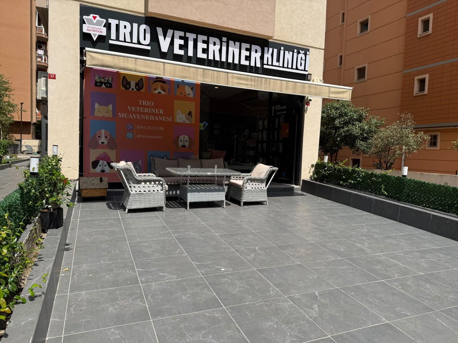 Trio Veteriner Kliniği tabelası ve giriş önündeki oturma alanı